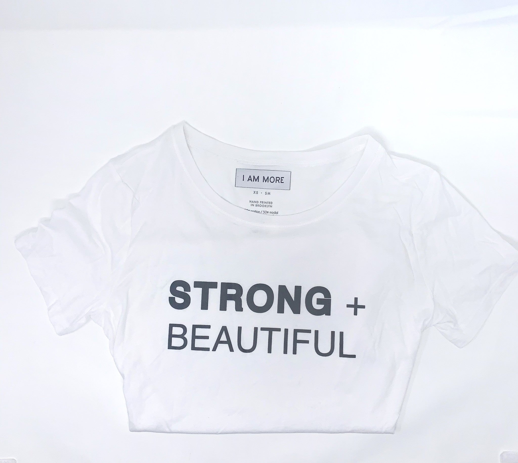 Strong + Beautiful white short sleeve t-shirt folded